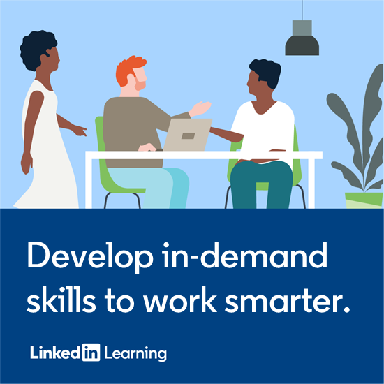 Three people by desk and computer