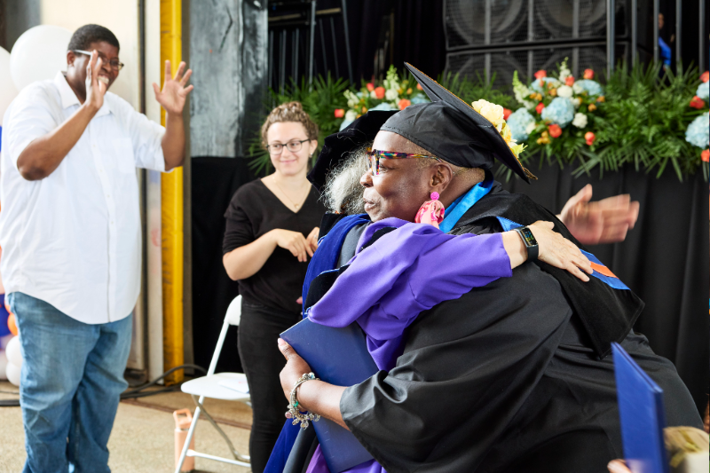A graduating student hugs a professor at KCC graduation