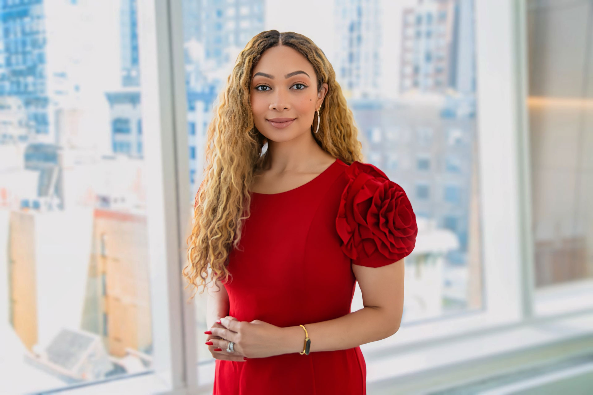 Photo of a woman with long curly hair wearing a red dress.